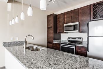 A kitchen with a granite counter top and a sink
